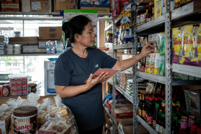 pemilik toko mengelola stok barang di rak